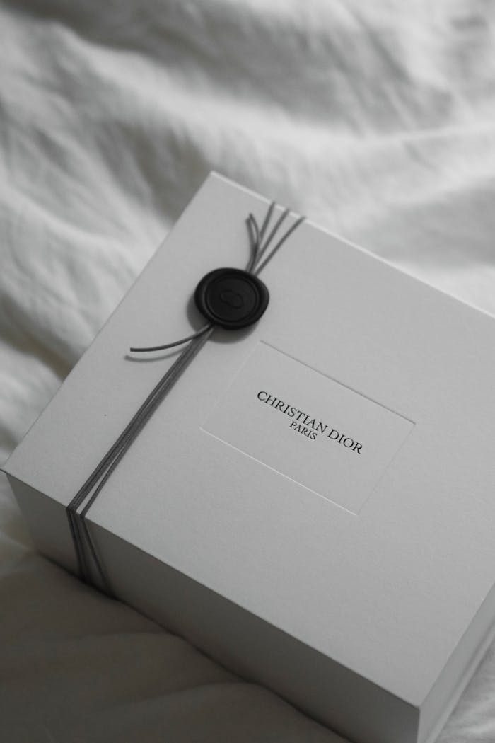 Discover the luxurious packaging of a Dior gift box, elegantly wrapped with a wax seal in Paris.