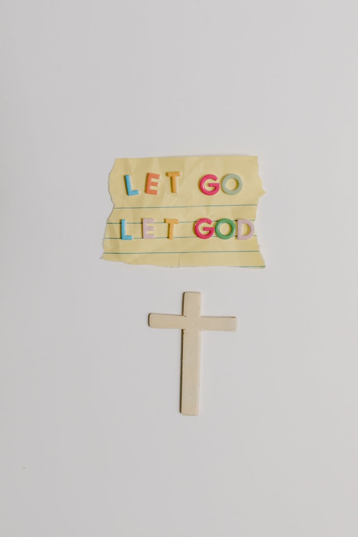 Colorful 'Let Go Let God' note and cross symbol illustrating Christian faith.